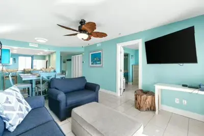 a living room with a couch and a flat screen tv at Commodore 202 - Thomas Drive Paradise in Panama City Beach