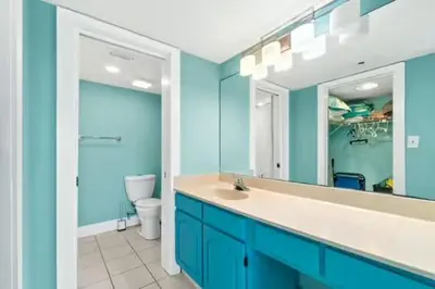 a bathroom with a sink and a toilet and a mirror at Commodore 202 - Thomas Drive Paradise in Panama City Beach
