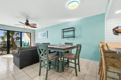 a living room with a table and chairs and a couch at Commodore 202 - Thomas Drive Paradise in Panama City Beach