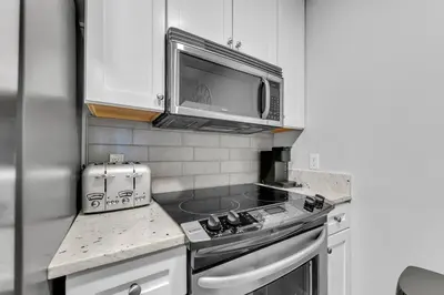 a kitchen with a stove and a microwave at Cassine Way 303 - Seagrove + Sunsets in Santa Rosa Beach