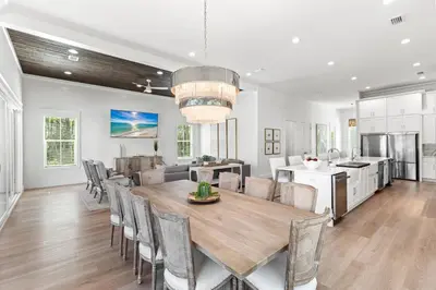 a kitchen and dining room with a wooden table and chairs at Coastal Opulence in Santa Rosa Beach