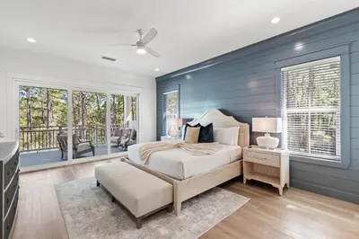 a bedroom with a bed with a blue accent wall at Coastal Opulence in Santa Rosa Beach