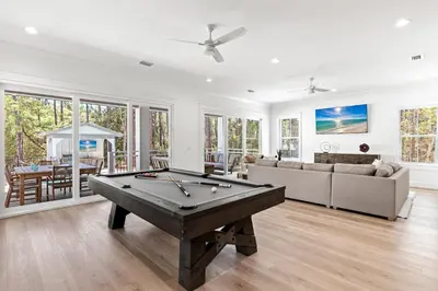 a living room with a pool table at Coastal Opulence in Santa Rosa Beach