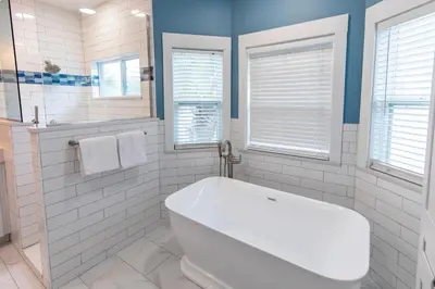 a white bathroom with a tub and windows at Blue Paradise in Seagrove Beach