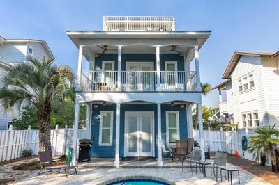 a blue house with a balcony and a swimming pool at Blue Paradise in Seagrove Beach