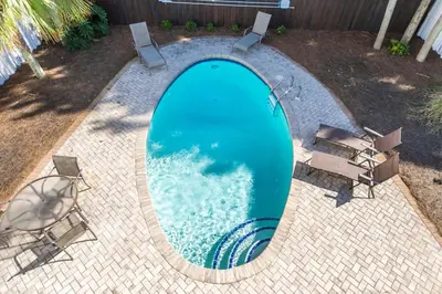 a swimming pool with chairs and a swimming pool at Blue Paradise in Seagrove Beach