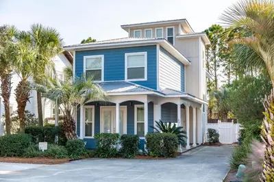 a blue house with palm trees in front of it at Blue Paradise in Seagrove Beach