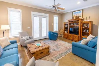 a living room with blue couches and a tv at Blue Paradise in Seagrove Beach