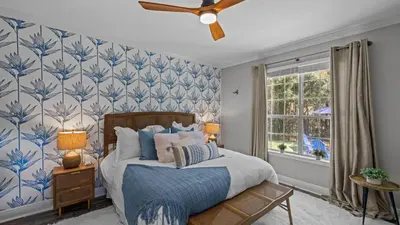 a bedroom with a bed with blue and white wallpaper at 30A Cottage Near the Beach with Golf Cart in Inlet Beach