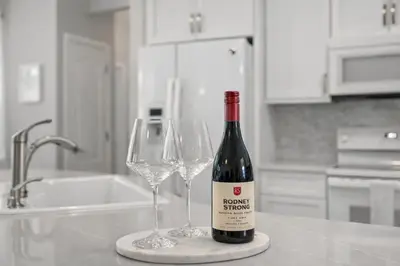 a bottle of wine sitting on a counter with two wine glasses at 30A Cottage Near the Beach with Golf Cart in Inlet Beach