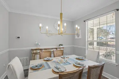 a dining room with a table and chairs and a chandelier at 30A Cottage Near the Beach with Golf Cart in Inlet Beach