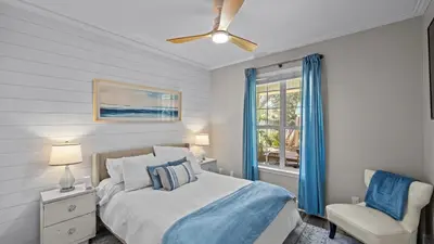 a bedroom with a bed and a chair and a window at 30A Cottage Near the Beach with Golf Cart in Inlet Beach