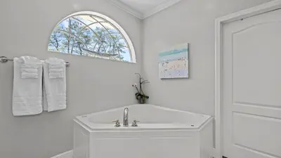 a white bathroom with a sink and a window at 30A Cottage Near the Beach with Golf Cart in Inlet Beach