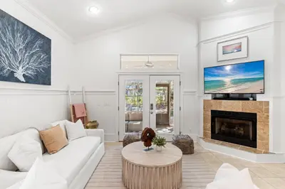 a living room with a white couch and a fireplace at Camp Seabreeze in Inlet Beach