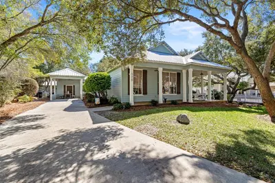 a white house with a porch and a driveway at Camp Seabreeze in Inlet Beach