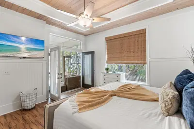 a bedroom with a bed and a ceiling fan at Camp Seabreeze in Inlet Beach