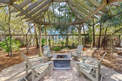 a group of chairs and a fire pit under a pergola at Camp Seabreeze in Inlet Beach