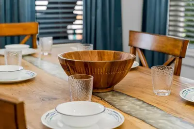 a wooden table with plates and a bowl on it at 30A Pet Friendly Beach House - Paradise Valle by Panhandle Getaways in Inlet Beach