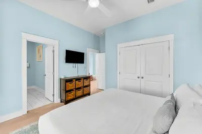 a bedroom with a white bed and a flat screen tv at 30A Pet Friendly Beach House - Paradise Valle by Panhandle Getaways in Inlet Beach