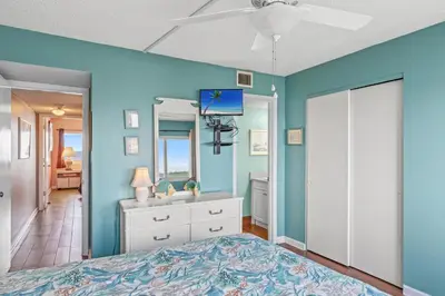 a blue bedroom with a bed and a ceiling fan at Pinnacle Port A-506 in Carillon Beach