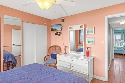 a bedroom with a bed and a dresser with a mirror at Pinnacle Port A-506 in Carillon Beach