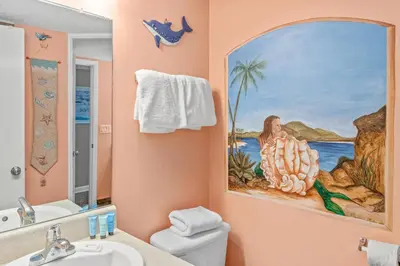 a bathroom with a painting of a woman on the wall at Pinnacle Port A-506 in Carillon Beach