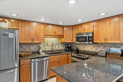 a kitchen with wooden cabinets and stainless steel appliances at Pinnacle Port A-514 in Carillon Beach