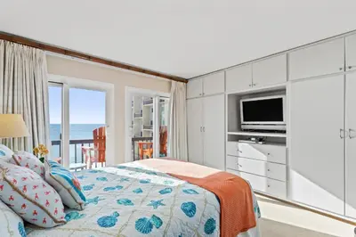 a bedroom with a bed with a television and a balcony at Pinnacle Port A-514 in Carillon Beach