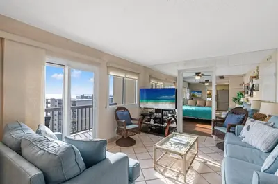 a living room with couches and a television and a bedroom at Pinnacle Port A-730 in Carillon Beach