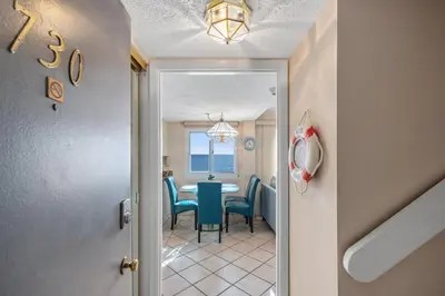 a dining room with a table and blue chairs at Pinnacle Port A-730 in Carillon Beach