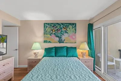 a bedroom with a bed with a blue bedspread at Pinnacle Port A-730 in Carillon Beach