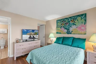 a bedroom with a blue bed and a bathroom at Pinnacle Port A-730 in Carillon Beach