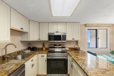 a kitchen with a sink and a microwave at Pinnacle Port A-730 in Carillon Beach