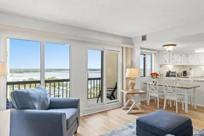 a living room with a couch and a table with a view at Pinnacle Port A-701 in Carillon Beach