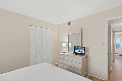 a bedroom with a bed and a television on a dresser at Pinnacle Port A-701 in Carillon Beach