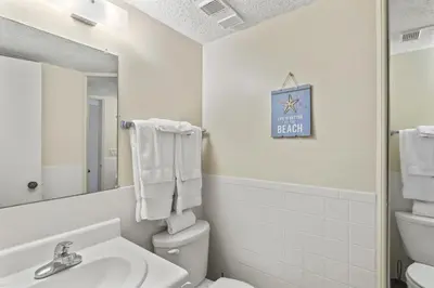 a bathroom with a sink and a toilet and a mirror at Pinnacle Port A-701 in Carillon Beach