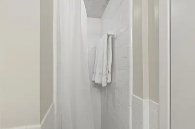 a white bathroom with a shower and a white towel at Pinnacle Port A-701 in Carillon Beach