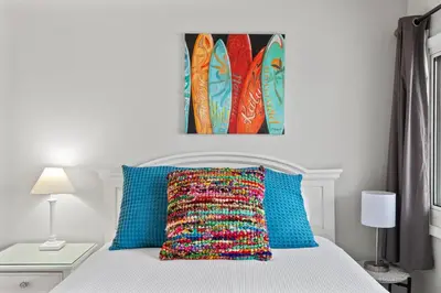 a bedroom with a bed with blue and orange pillows at Pinnacle Port, A-708 in Carillon Beach