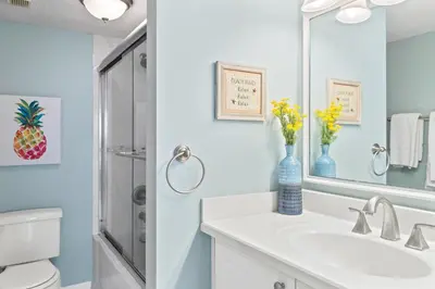 a white bathroom with a sink and a mirror at Pinnacle Port, A-708 in Carillon Beach