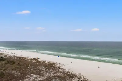 a beach with a group of people in the ocean at Pinnacle Port, A-708 in Carillon Beach