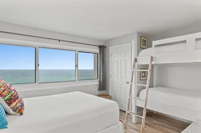 a bedroom with two bunk beds and a view of the ocean at Pinnacle Port, A-708 in Carillon Beach