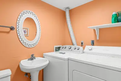 a laundry room with a washing machine and a sink at Pinnacle Port Penthouse11 in Carillon Beach