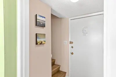 a hallway with stairs and pictures on the wall at Pinnacle Port Penthouse11 in Carillon Beach