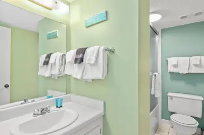 a bathroom with a sink and a toilet and a mirror at Pinnacle Port Penthouse11 in Carillon Beach