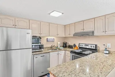 a kitchen with white appliances and marble counter tops at Pinnacle Port Penthouse11 in Carillon Beach