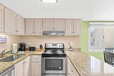 a kitchen with white cabinets and a stove at Pinnacle Port Penthouse11 in Carillon Beach