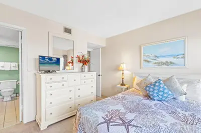 a bedroom with a bed and a dresser with a television at Pinnacle Port Penthouse11 in Carillon Beach
