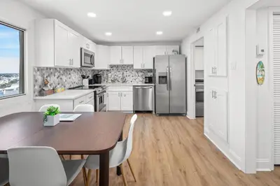 a kitchen with a table and a refrigerator at Pinnacle Port Penthouse 15 in Carillon Beach
