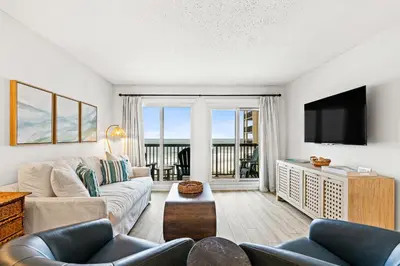 a living room with a couch and a tv at Pinnacle Port C1-401 in Carillon Beach