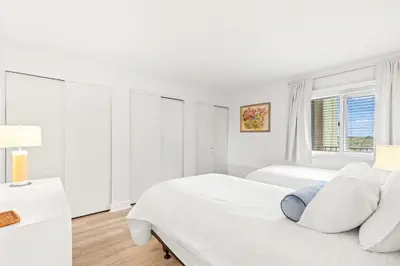 a white bedroom with two beds and a window at Pinnacle Port C1-401 in Carillon Beach